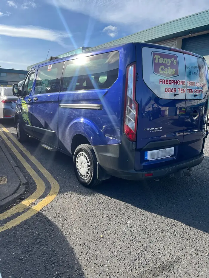 Tony's Cabs minibus, branded with the freephone number and tagline