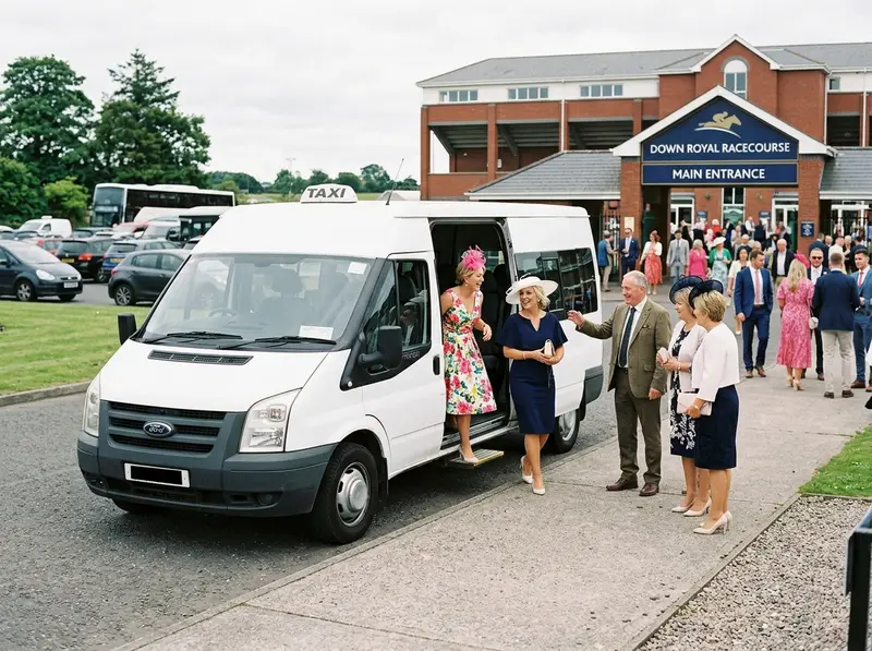 Taxi minibus dropping racegoers at a racecourse entrance