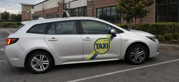 Tony's Cabs saloon taxi, a Toyota Corolla estate, parked outside a Drogheda business park